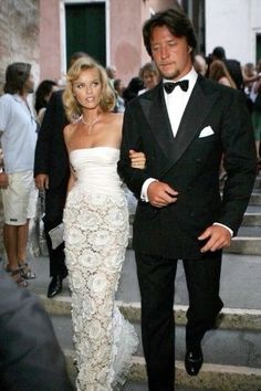 a man in a tuxedo walking next to a woman