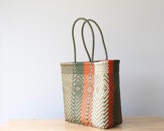 WHY YOU'LL LOVE THIS TOTE: Discover the beauty of Mexican craftsmanship with this one-of-a-kind handwoven bag, meticulously made by artisans in Mexico using recycled plastic. This unique design features a striking combination of Olive Green, Gold, Orange & Beige, making it an essential piece for your year-round wardrobe. Perfect for every season and occasion, this tote offers ample space and a flat base for stability. Highly rated for its vibrant colors, exceptional quality, and craftsmanship, t Mexican Bags, Mexican Bag, Round Wardrobe, Handwoven Bag, Basket Tote, Medium Handbags, Medium Tote, Gold Orange, Small Handbags