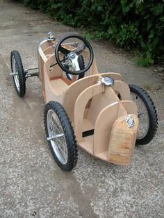 an old fashioned pedal car is sitting on the ground