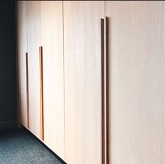 an empty room with wooden cupboards and carpeted flooring in front of it