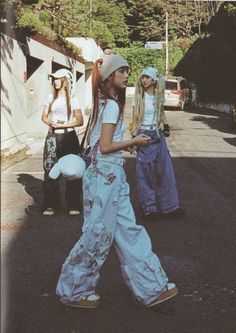 two girls walking down the street with one carrying a stuffed animal in her hand and another wearing overalls