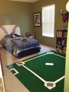 a bedroom with a baseball themed bed and green carpet