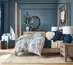 a bedroom with blue walls and white bedding in the center is a wooden four poster bed