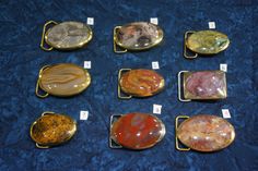 nine different types of marbles on display in gold trays with price tags for each one