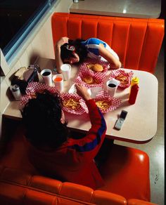 two people sitting at a table with plates of food