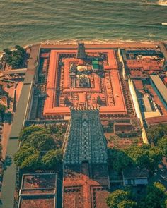 an aerial view of a large building next to the ocean