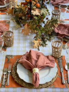 the table is set with plates, silverware and napkins