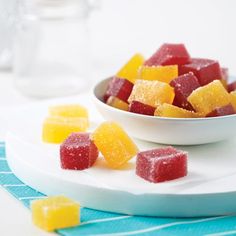 a bowl filled with gummy bears on top of a white plate next to a blue towel