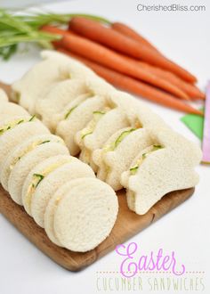 there are carrots and some kind of sandwich on the cutting board next to it