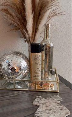 a mirror and some bottles are on a table with a decorative object in the background