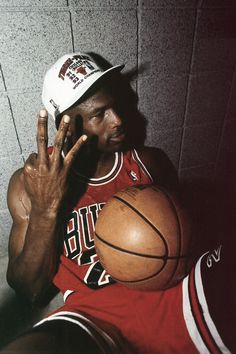 a man holding a basketball in front of his face