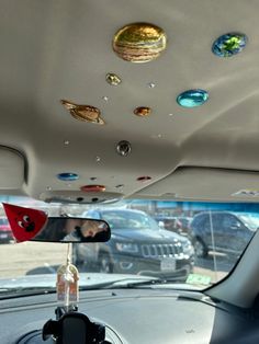 the interior of a car with several different colored glass objects on the ceiling and in the passenger side mirror