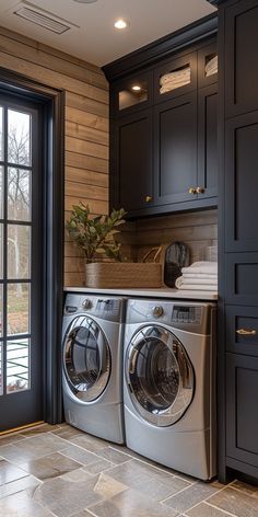 a washer and dryer in a kitchen with dark cabinets