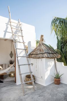 a white house with a hammock and palm trees