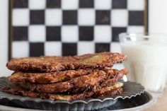 some fried food on a plate next to a glass of milk