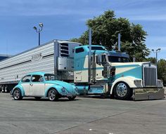 a blue and white semi truck parked next to a car