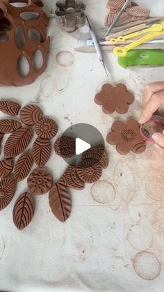 a person is making clay flowers and leaves