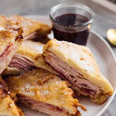 ham and cheese pastrami on a white plate with a cup of coffee next to it