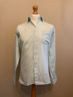 Striking 80s vintage shirt in mint green with tonal shadow stripe pattern cotton polyester blend from the Europa Collection by Van Heusen.  Details: straight collar, long sleeves, barrel cuffs, regular fit.  As new (only unwrapped for photo shoot) 50% Cotton 50% Polyester  Made in England  Size M Chest 40" Collar 15" Measurements Flat  Pit to Pit 20" 50cm Shoulder to Shoulder 17" 44cm Sleeve 26" 67cm Length 31" 79cm Green Collared Shirt For Semi-formal Occasions, Semi-formal Green Long Sleeve Shirt, Green Long Sleeve Semi-formal Shirt, Green Long Sleeve Business Top, Green Long Sleeve Tops For Business, Business Long Sleeve Green Shirt, Green Cotton Collared Dress Shirt, Business Green Long Sleeve Shirt, Green Long Sleeve Cotton Dress Shirt