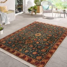 a large rug is on the floor in front of a patio with chairs and potted plants