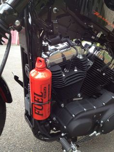 a close up of a motorcycle engine with an orange canister on the front tire