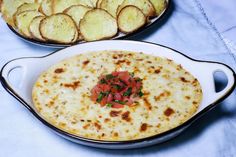 two pans filled with food sitting on top of a blue cloth covered tablecloth