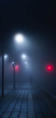 two red traffic lights on a foggy street