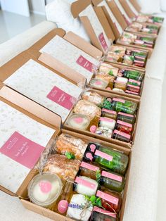 boxes filled with different types of food on top of a white table covered in paper