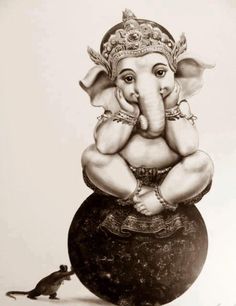 an elephant statue sitting on top of a ball next to a small rat in front of it