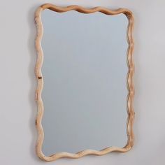 a mirror that is made out of wood and has wavy lines on the edge of it