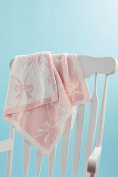 a white rocking chair with a pink towel on it