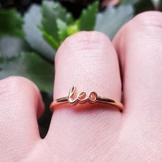 a close up of a person's hand holding a ring with the word love on it