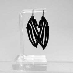 Exude your animal magnetism with the Kaden & Kai Zebra Bicycle Tube Earrings. The alluring nature of this animal print is hard to resist! Make a statement by pairing it with a sleek black ensemble or go completely wild and mix it up. Features Length: 2" Color: Black Unique Feature: Looks like a tattoo Materials: Rubber bicycle inner tube, Gun Black Iron Posts (Nickel and Lead Free) Source: Tubes donated by the Cycle Loft in MA Handcrafted in: Lexington, Massachusetts Optional Add gift wrapping Modern Black Earrings For Party, Edgy Black Earrings For Party, Edgy Black Earrings For Gift, Black Minimalist Jewelry For Everyday, Edgy Black Party Earrings, Black Edgy Earrings, Black Laser Cut Jewelry As Gift, Black Laser Cut Jewelry Gift, Modernist Black Earrings As Gift