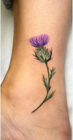 a purple flower tattoo on the ankle