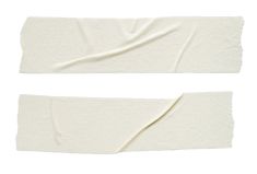 two pieces of white paper are shown on a white background, one is folded up and the other has torn off