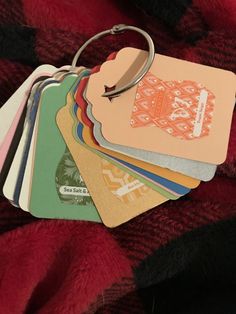 a pile of credit cards sitting on top of a red blanket next to a pair of scissors