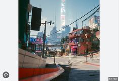 a city street filled with lots of traffic next to tall buildings in the middle of the day