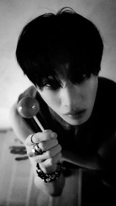 black and white photograph of a woman holding a spoon in her right hand while looking at the camera