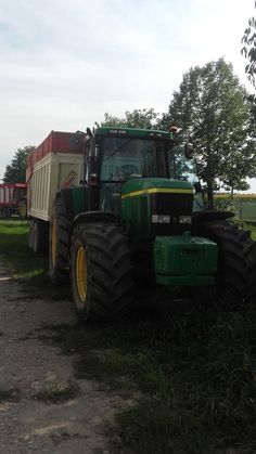 a large green tractor parked on top of a grass covered field