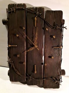 a clock made out of wood with barbed wire on the sides and numbers marked in gold