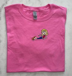 Lizzie McGuire t-shirt.Message us for more color options. Select your color of t-shirt and size and bring the magic home.T shirts with unisex sizing.  Please refer to sizing chart measurements.Sample shown stitched on ice grey Sporty Pink Top With Custom Print, Customizable Sporty Pink Tops, Pink Cotton T-shirt With Custom Text, Customizable Casual Pink Shirt, Casual Customizable Pink Shirt, Pink Short Sleeve T-shirt With Custom Embroidery, Customizable Pink Cotton Shirt, Casual Pink Tops With Custom Text, Casual T-shirt With Custom Text For School