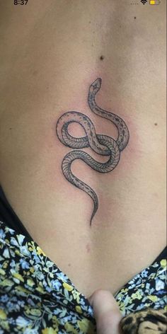 a woman's stomach with a tattoo on her side and a snake in the middle