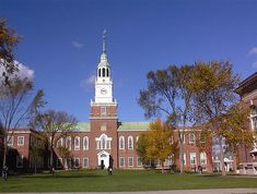 a large building with a clock tower in the middle of it's front yard