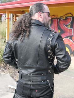 Here's one heavy metal jacket for you. A men's leather motorcycle jacket laced with chain and lots of chrome. This cool leather biker jacket comes with zip off sleeves and a zip out lining. A heavy buffalo leather jacket/vest with belt is loaded with extra hardware including metal chain, rivets, snaps, zippers and other chrome hardware for that flashy rider, an entertainer or those who just want to be noticed. Other features include snap down collar, shoulder epaulets, 3 front zip pockets, a flap lighter pocket, an inside chest pocket and made of premium soft buffalo leather. A Jamin Leather® Exclusive! Sizes: S, M, L, XL, 2X, 3X. +$10 for 2X-3X. [10#] adjustable belt snap down collar shoulder epaulets 3 front zip pockets flap lighter pocket inside chest pocket zip off sleeves YKK quality Gothic Leather Outerwear For Biker Events, Moto Biker Jacket With Rivets For Biker Events, Biker Jacket With Rivets For Biker Events, Biker Style Jacket With Rivets For Biker Events, Gothic Leather Jacket For Biker Events, Biker Outerwear With Rivets For Biker Events, Moto Leather Jacket With Rivets For Biker Events, Biker Leather Jacket With Rivets, Biker Leather Jacket With Rivets For Biker Events