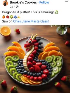 a plate that has fruit in the shape of a dragon on it, and some strawberries