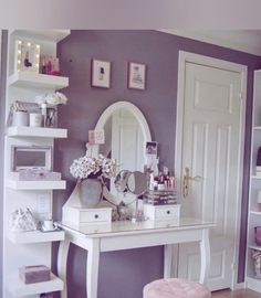 a white desk topped with a mirror next to a shelf filled with lots of clutter