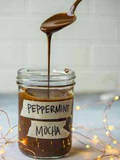 a glass jar filled with chocolate and caramel syrup being drizzled over it