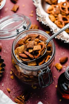 a glass jar filled with cheetos sitting on top of a table next to other food