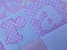 pink and white patchwork baby quilt with letters on it's side, along with polka dots