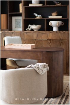 an upholstered chair sits in front of a bookcase